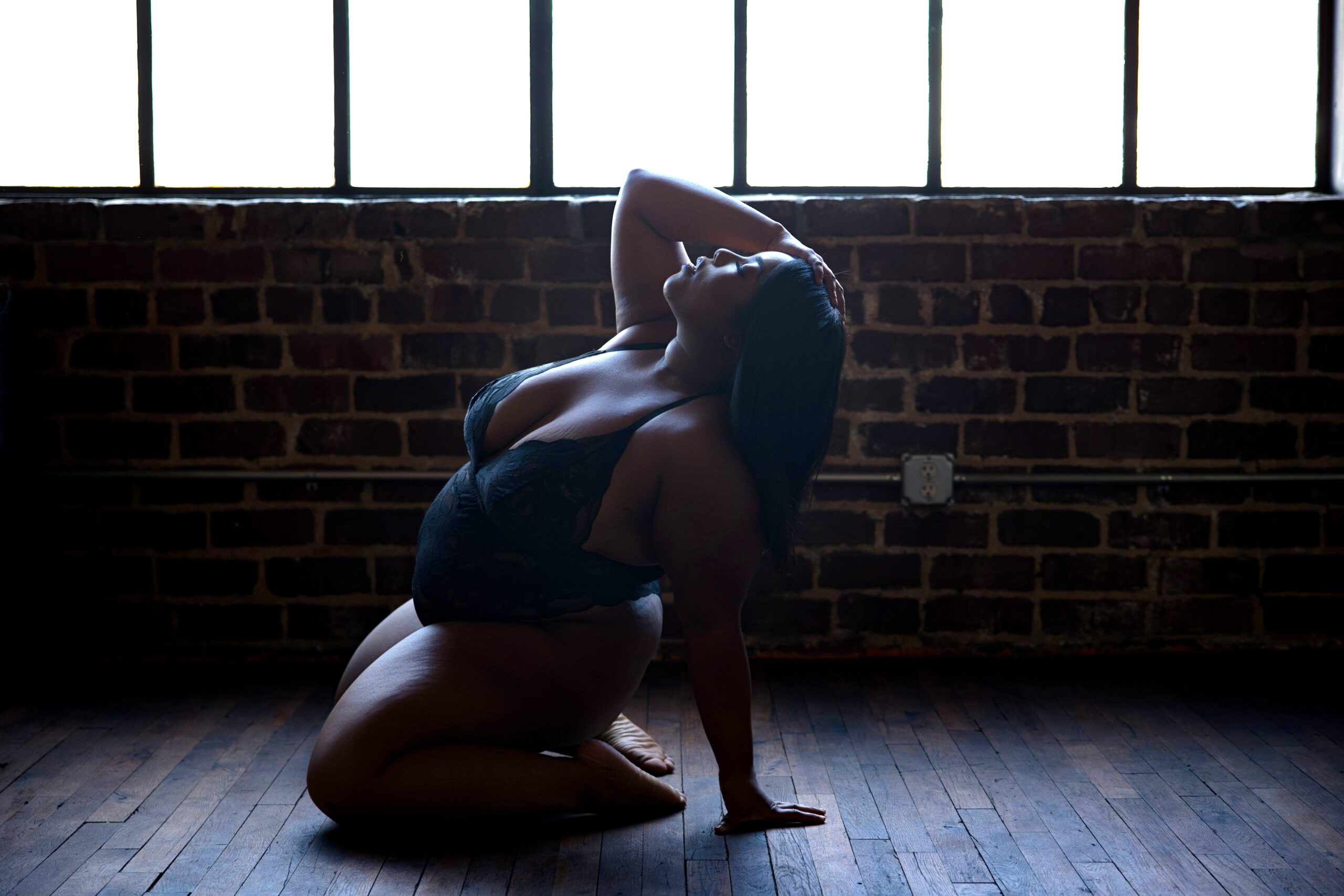 Woman embracing her natural curves during a boudoir photoshoot