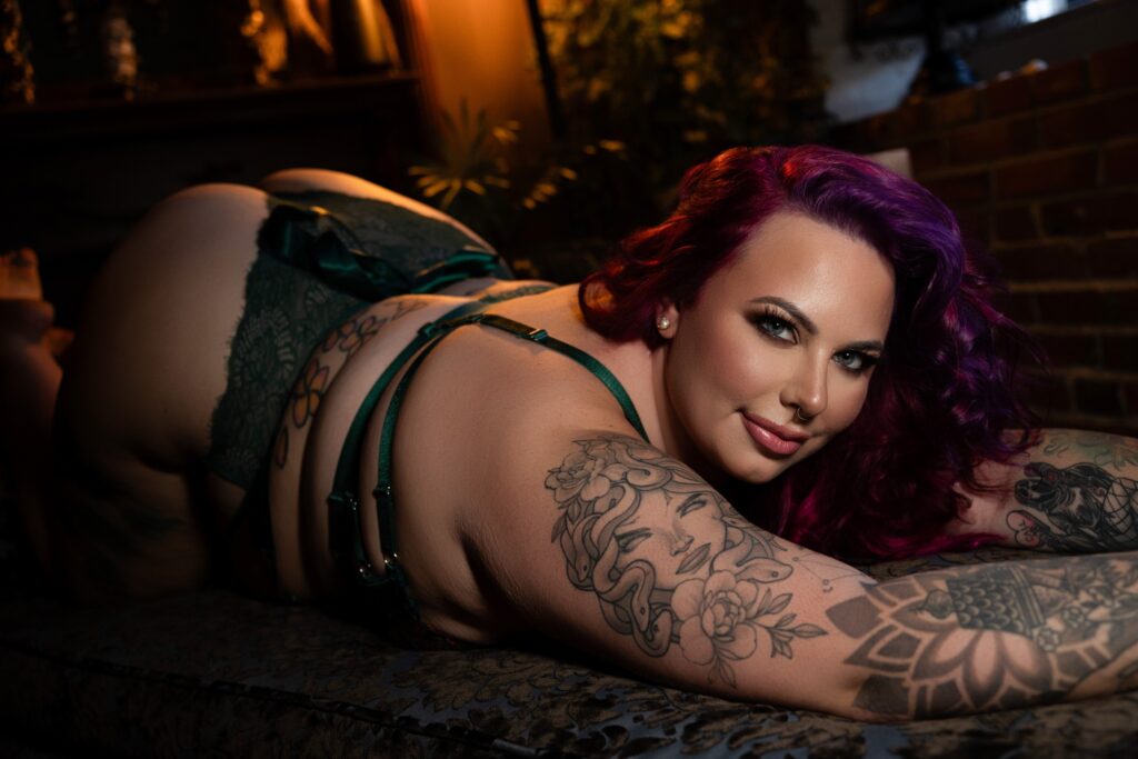 Curvy woman being guided into a flattering boudoir pose during her photoshoot