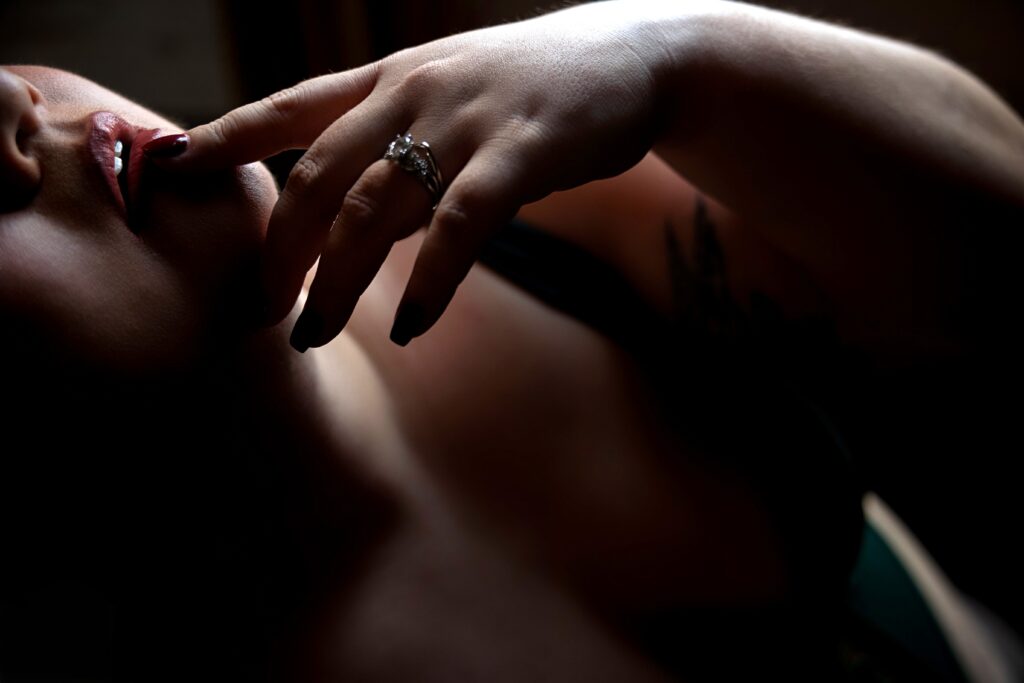 Close up of finger touching lip during a bridal boudoir session