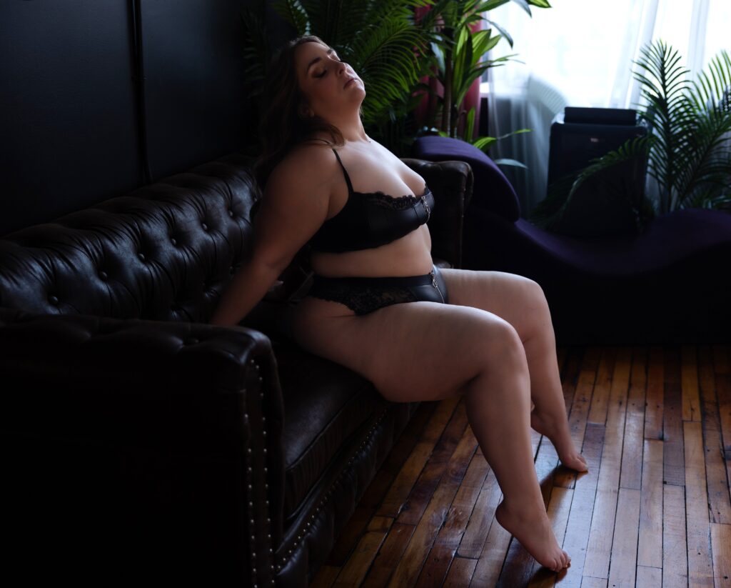 Woman sitting on a couch during a boudoir session