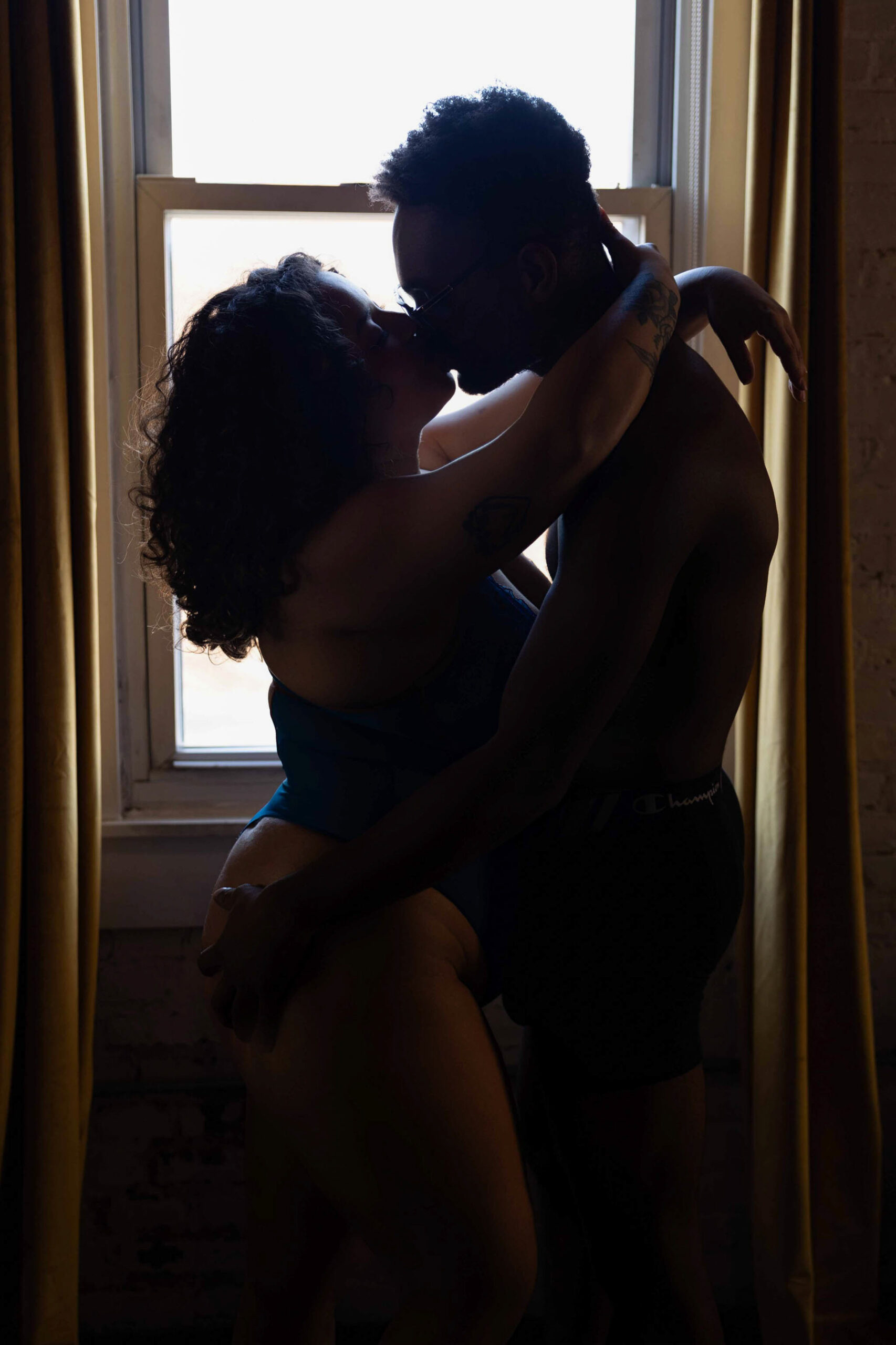A couple in silhouette kissing in a window during one of their romantic getaways in maryland